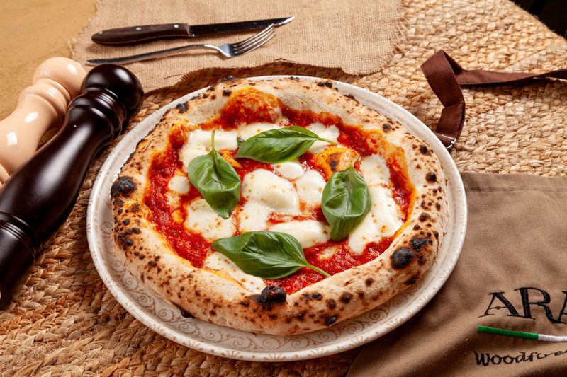 Dewey's pizza signature Margherita — fresh basil and mozzarella