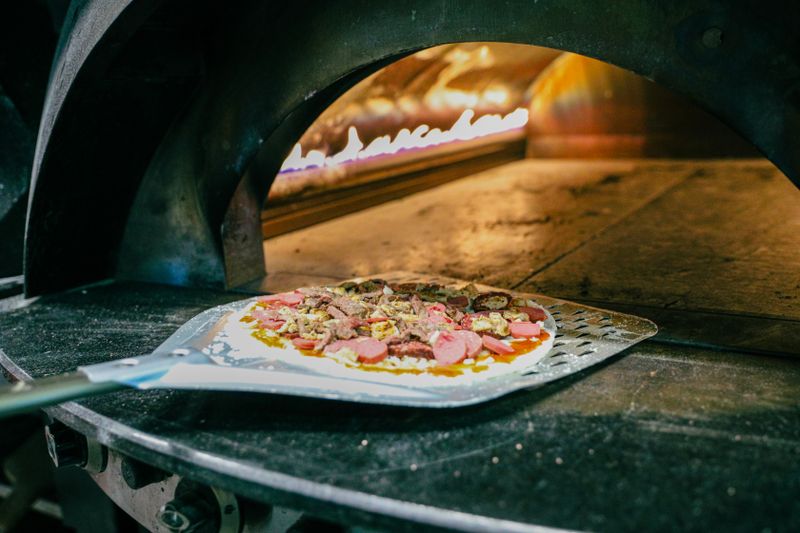 The signature wood-fired oven station at Dewey's pizza kitchen
